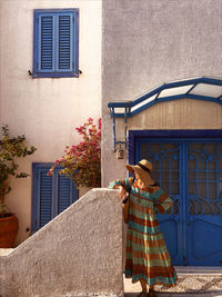 Rear view of woman standing against building