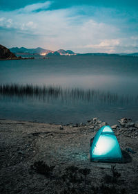 High angle view of illuminated tent by lake at dusk