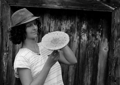 Woman holding mushroom while standing outdoors