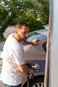 Side view of man repairing car