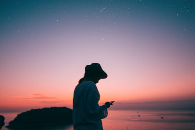 Silhouette man standing against sky during sunset