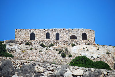 Low angle view of historical building against clear blue sky