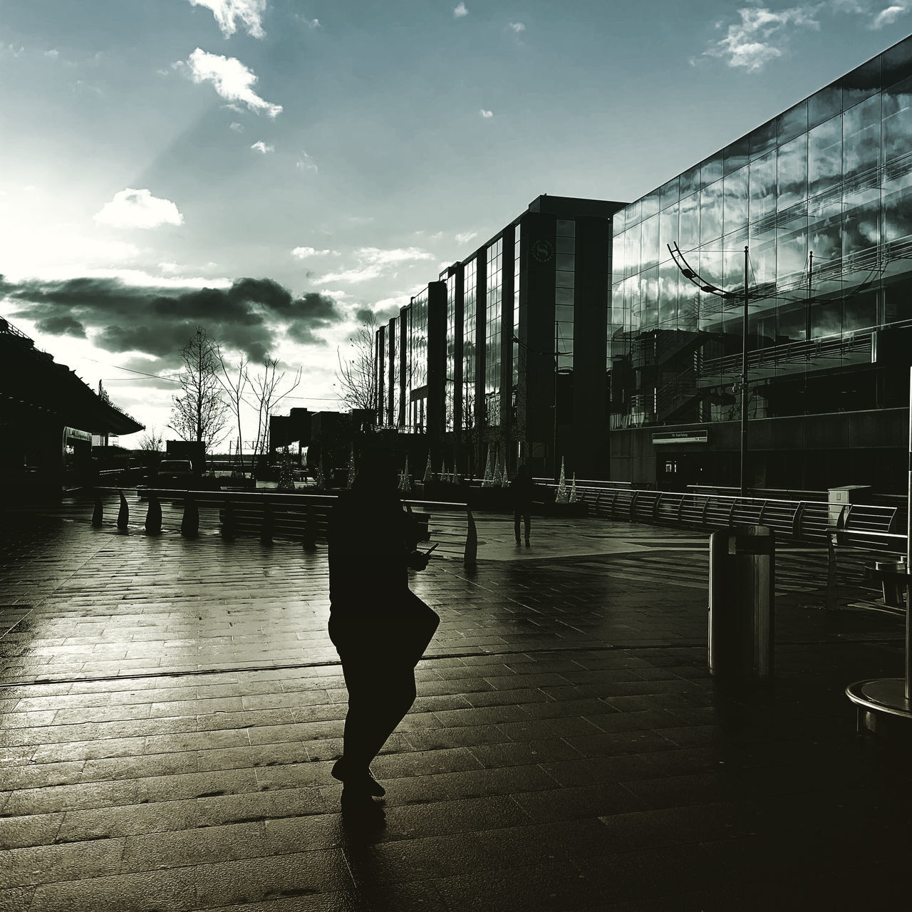 REAR VIEW OF WOMAN WALKING ON FOOTPATH AMIDST BUILDINGS