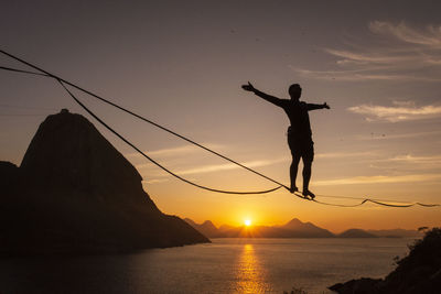 Beautiful sunrise view of man walking on highline with sugar loaf