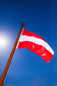 Low angle view of flag against blue sky