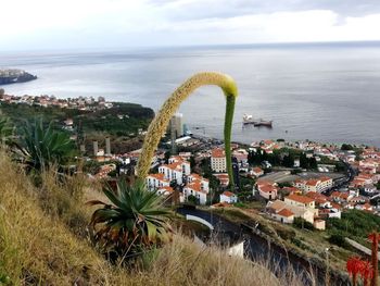 High angle view of cityscape by sea against sky