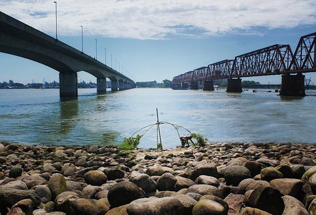 water, connection, bridge - man made structure, transportation, built structure, sky, river, architecture, engineering, bridge, sea, rock - object, stone - object, cloud - sky, nature, tranquility, diminishing perspective, day, outdoors, pier