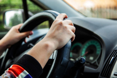 Midsection of woman driving car