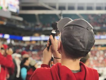 Rear view of boy wearing cap at stadium