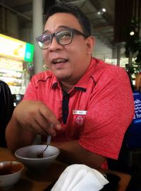 Portrait of man holding ice cream in restaurant