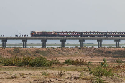 Train on bridge against clear sky