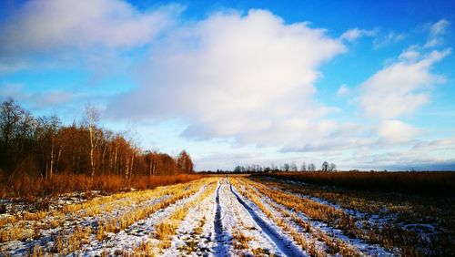 Country road against sky during winter
