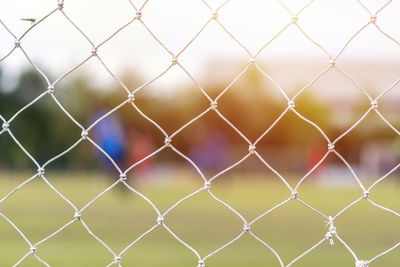 Full frame shot of soccer field seen through net