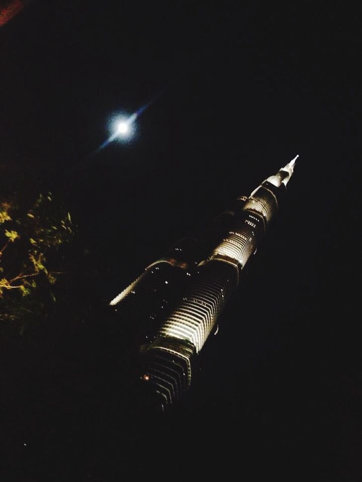 night, illuminated, low angle view, architecture, built structure, building exterior, tall - high, no people, lighting equipment, copy space, tower, light - natural phenomenon, modern, outdoors, dark, skyscraper, sky, city, tilt, clear sky