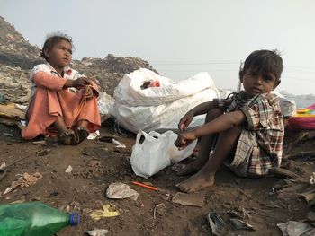 Portrait of siblings sitting on field