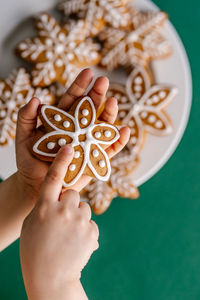 Ginger christmas cookies in children's hands on the background of the christmas tree.