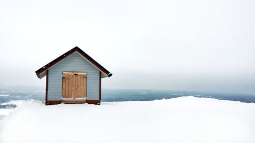 House on snow covered building against sky