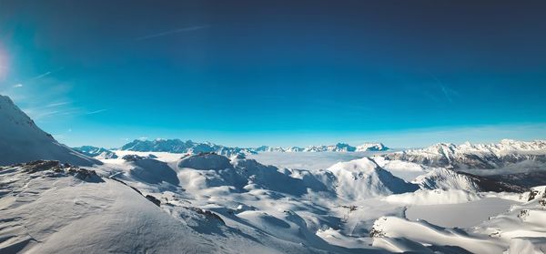 Scenic view of snowcapped mountains against blue sky