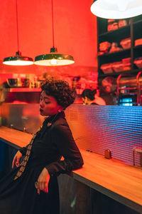 Side view of young woman looking away at night