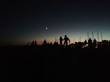 Silhouette people against clear sky at night