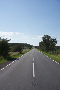 Empty road along countryside landscape