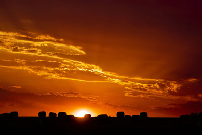 Scenic view of silhouette landscape against orange sky