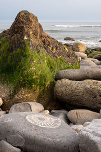 Rocks on beach against sky