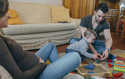 Father and son sitting on sofa