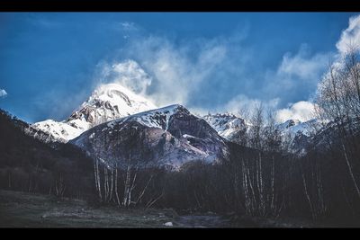 Snow covered mountain against cloudy sky