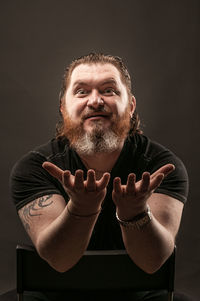 Portrait of man standing against black background