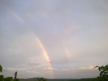 Low angle view of rainbow against sky at sunset