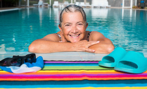 Portrait of a smiling young woman swimming in pool