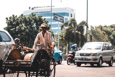 People riding motorcycle on road in city