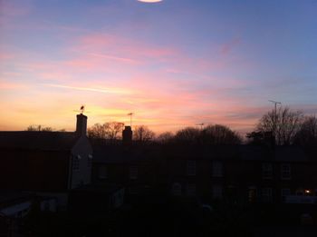 Silhouette of building against sky at sunset