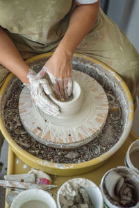 Midsection of woman making pottery in workshop