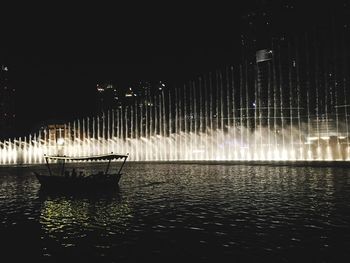 Illuminated boats in water at night