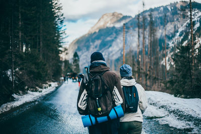 Rear view of people on snowcapped mountain