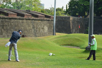 Full length of man photographing on golf course