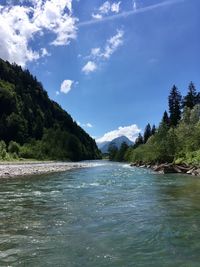 Scenic view of river and mountains against sky