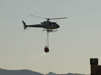 Low angle view of helicopter flying in sky