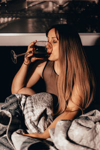 Woman drinking wine while sitting at home