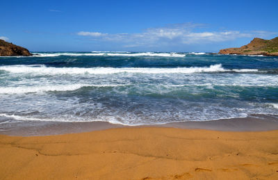 Scenic view of beach against blue sky