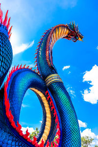 Low angle view of dragon sculpture against blue sky