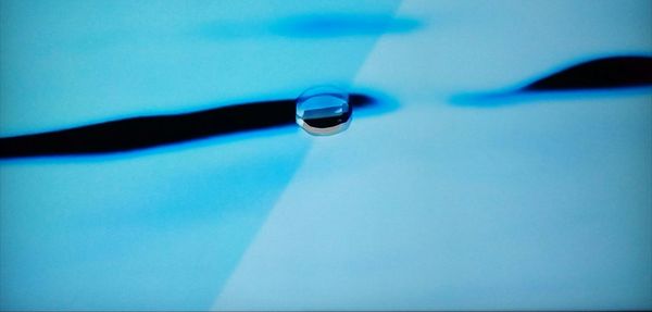 Close-up of water drop against blue background