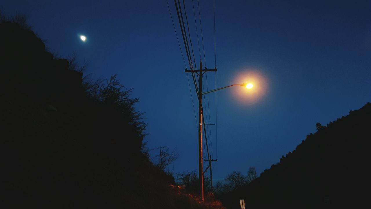 low angle view, silhouette, electricity, clear sky, moon, electricity pylon, blue, power line, sky, tranquility, beauty in nature, nature, dusk, power supply, copy space, sun, street light, tranquil scene, sunset, scenics