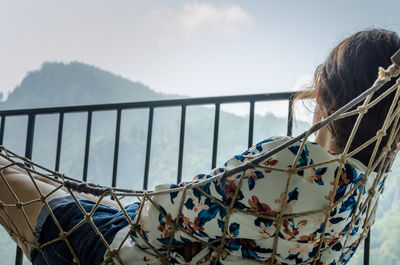 Woman relaxing in hammock at balcony