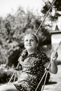 Young woman sitting on swing at playground