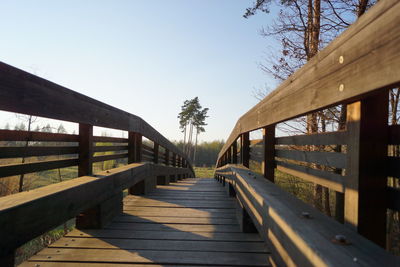 Footbridge over pier against clear sky