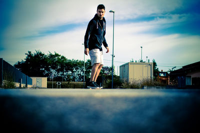 Full length of man skateboarding on road against sky