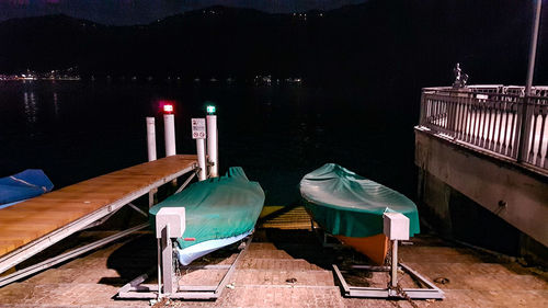 Boats moored by pier on lake against sky